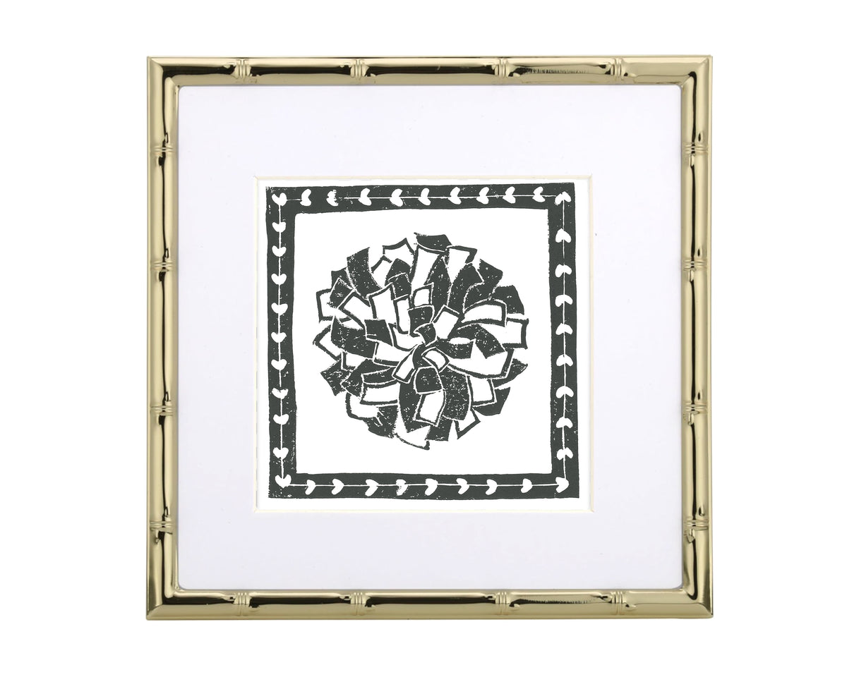 Framed artwork with a black and white pompon design on a white background