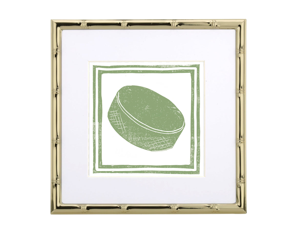 Framed artwork with a green hockey puck design on a white background
