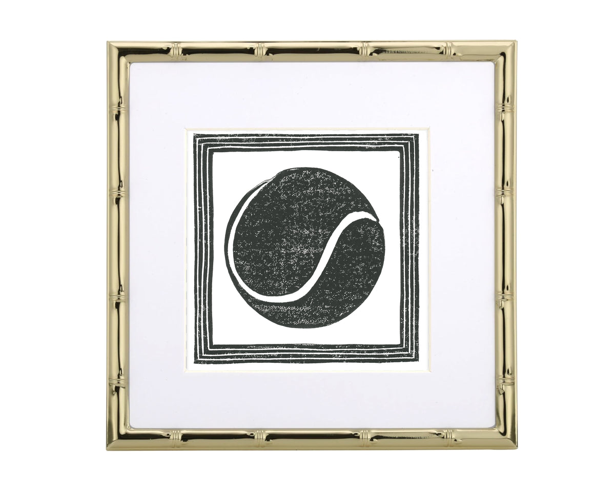 Framed artwork with a black tennis ball design on a white background