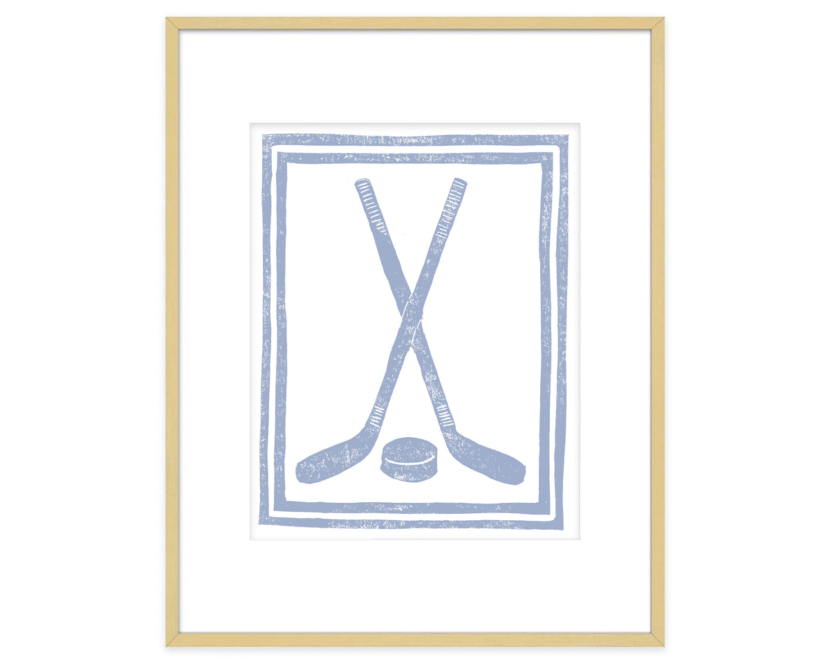 Framed artwork of crossed hockey sticks and a puck on a white background