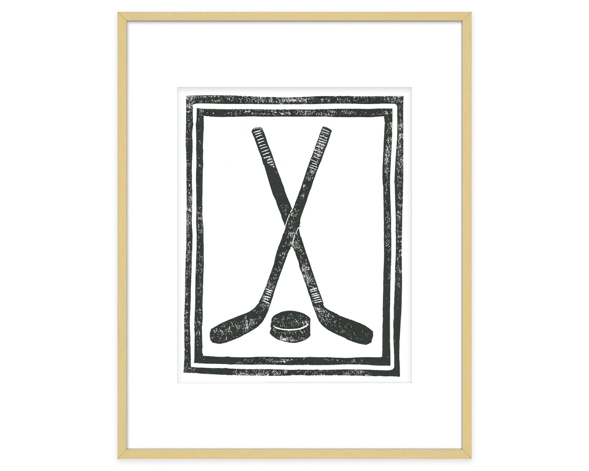 Framed artwork of crossed hockey sticks and a puck on a white background
