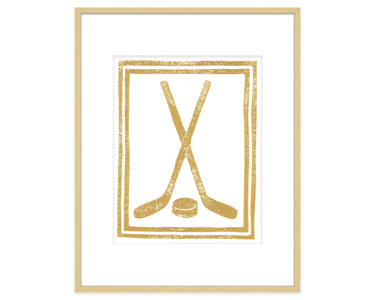 Framed artwork with gold hockey sticks and puck design on a white background