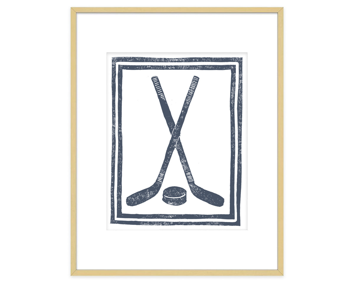 Framed artwork with crossed hockey sticks and a puck on a white background