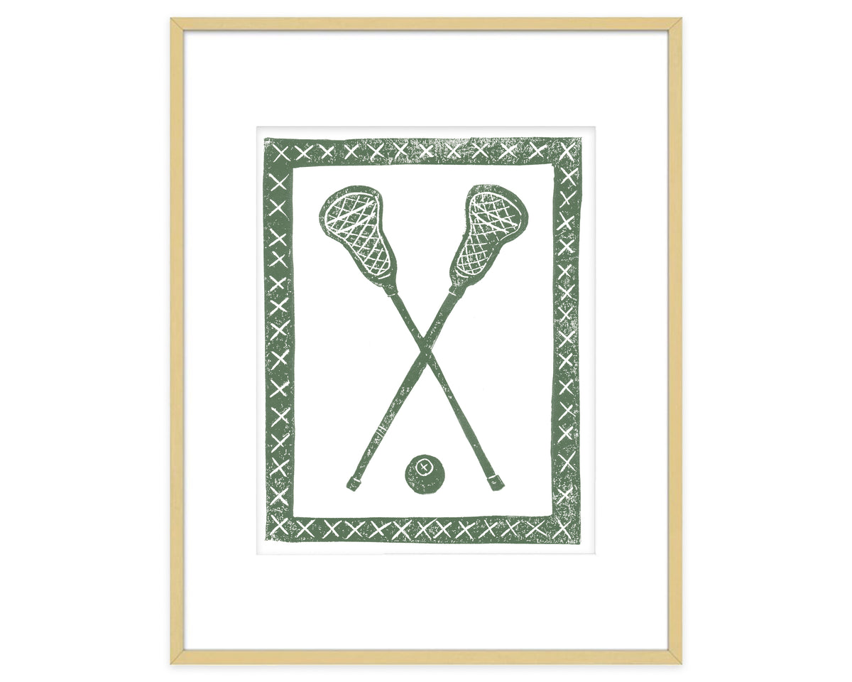 Framed artwork of two crossed lacrosse sticks and a ball with a decorative border on a white background.