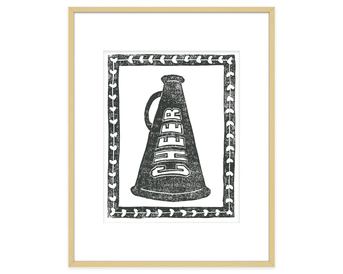 Framed artwork of a black and white megaphone with 'CHEER' text on a white background