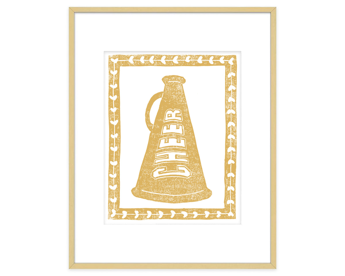 Framed artwork of a gold megaphone with 'CHEER' text on a white background