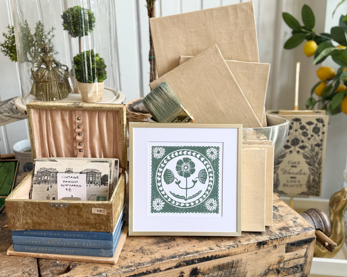 Decorative items including a framed print, books, and stationery on a wooden surface.