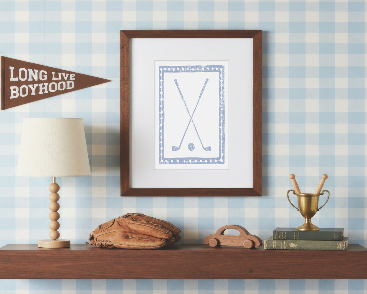 Framed artwork on a shelf with decorative items against a checkered wall.