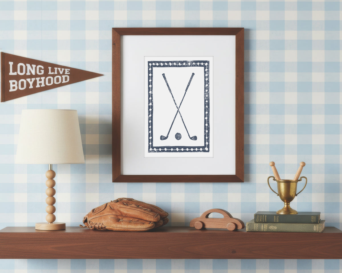 Framed artwork on a shelf with decorative items against a checkered wall.