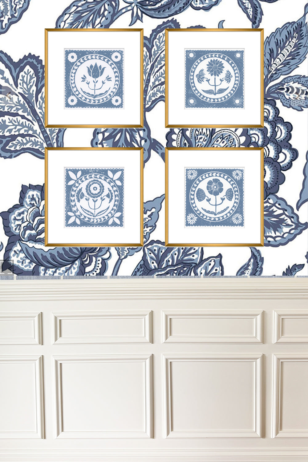 Four framed blue and white decorative prints on a floral wallpapered wall.