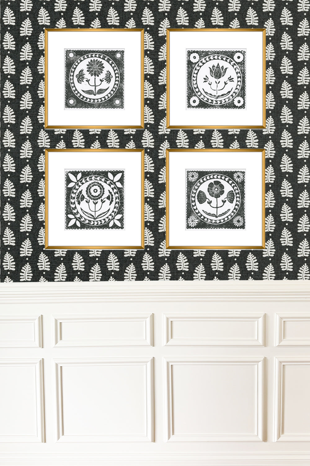 Four framed black and white prints on a decorative wall with leaf pattern