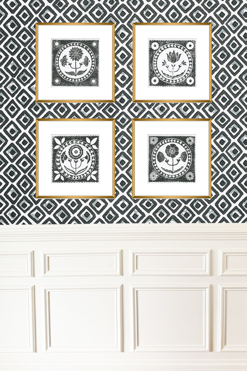 Four framed black and white prints on a geometric patterned wall above white paneling.