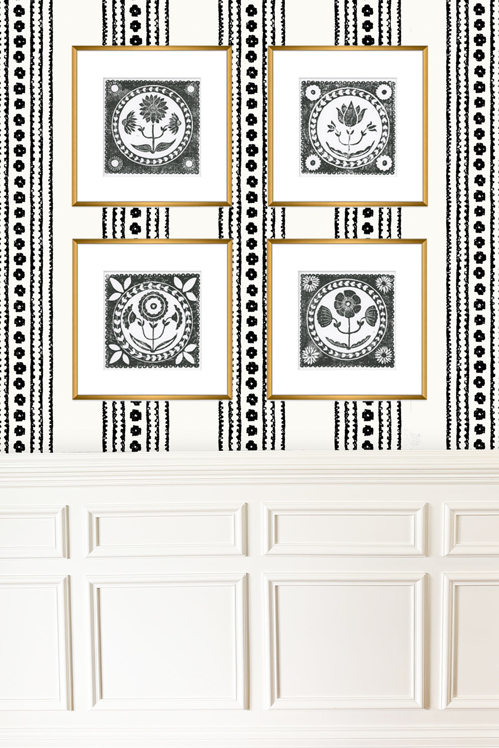 Four framed black and white prints on a wall with decorative black and white striped border.