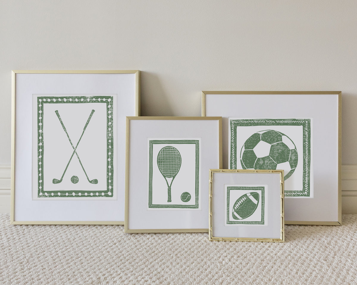 Four framed sport themed block prints on a white carpeted floor leaning up to a white wall