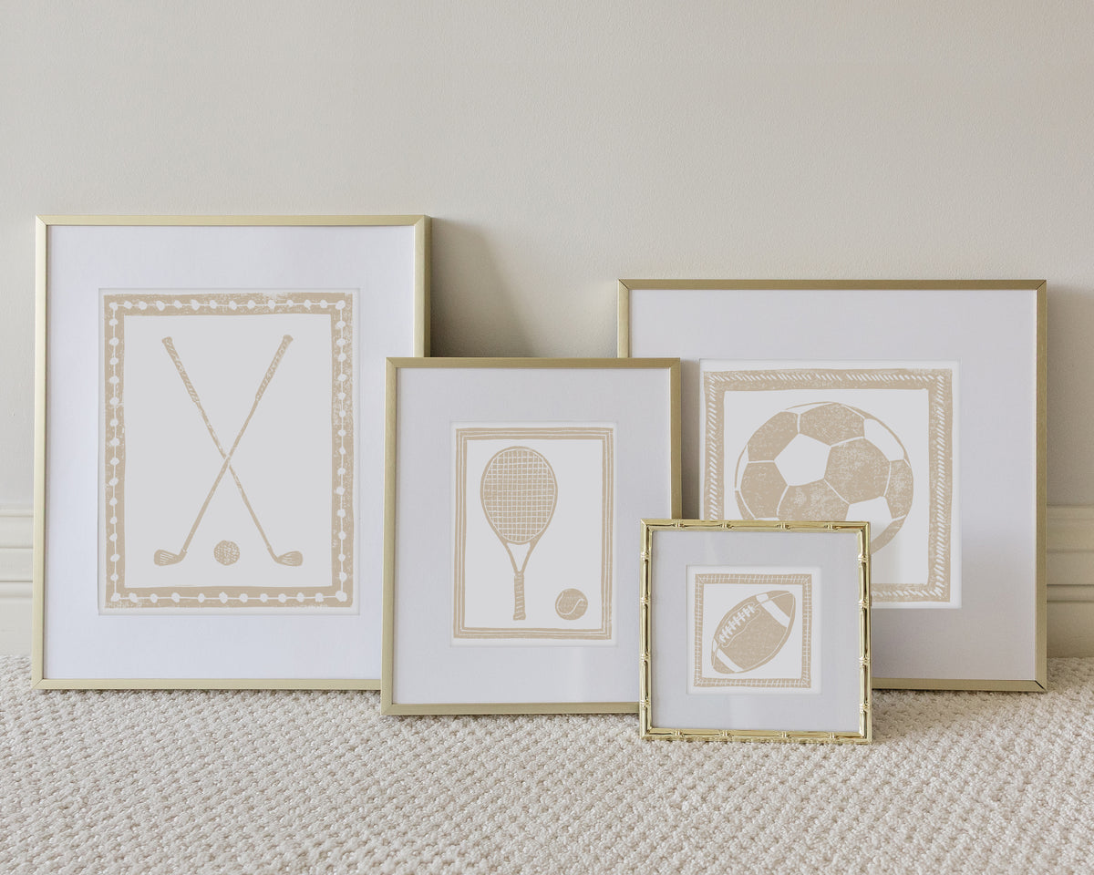 Four framed sport themed block prints on a white carpeted floor leaning up to a white wall