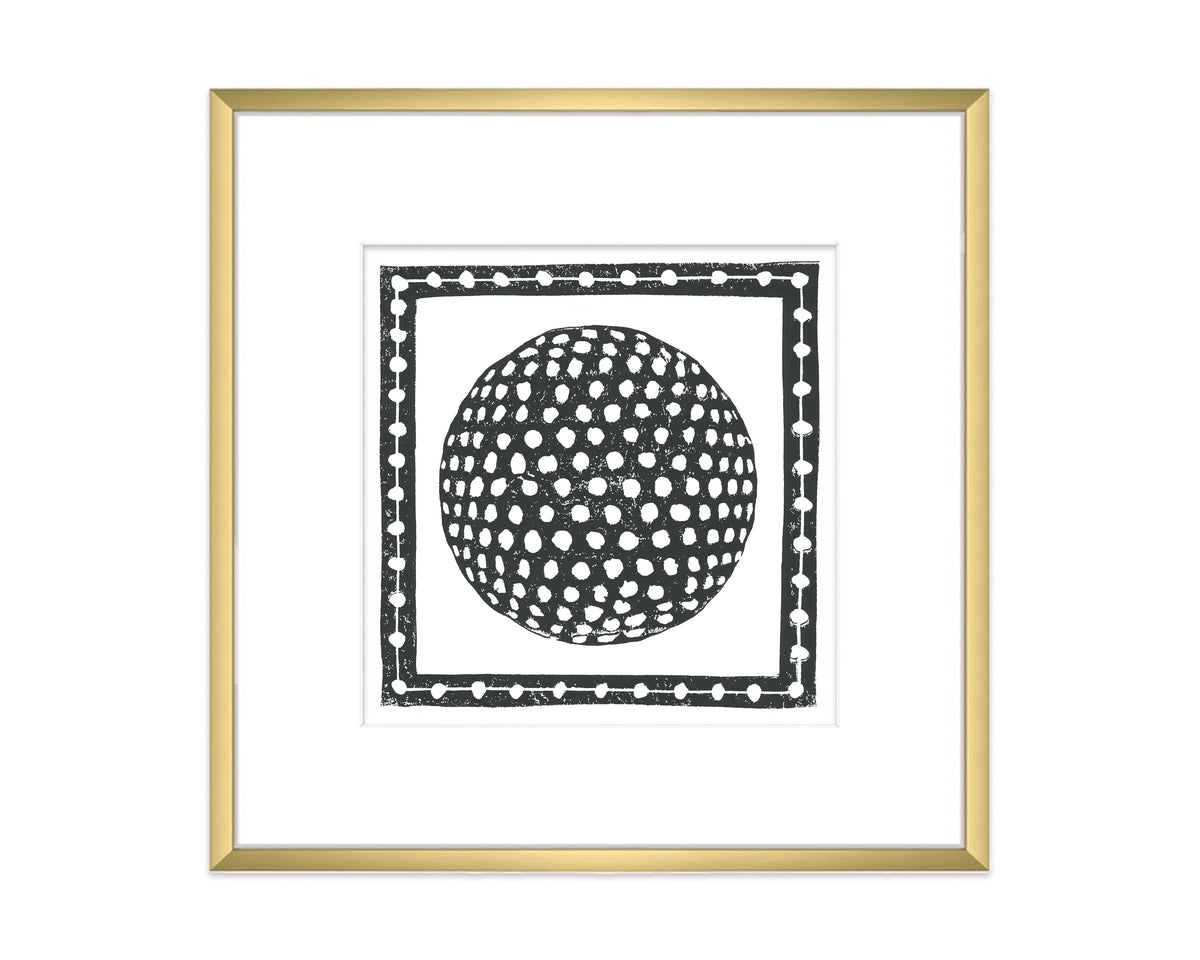 Framed artwork of a black and white golf ball design on a white background