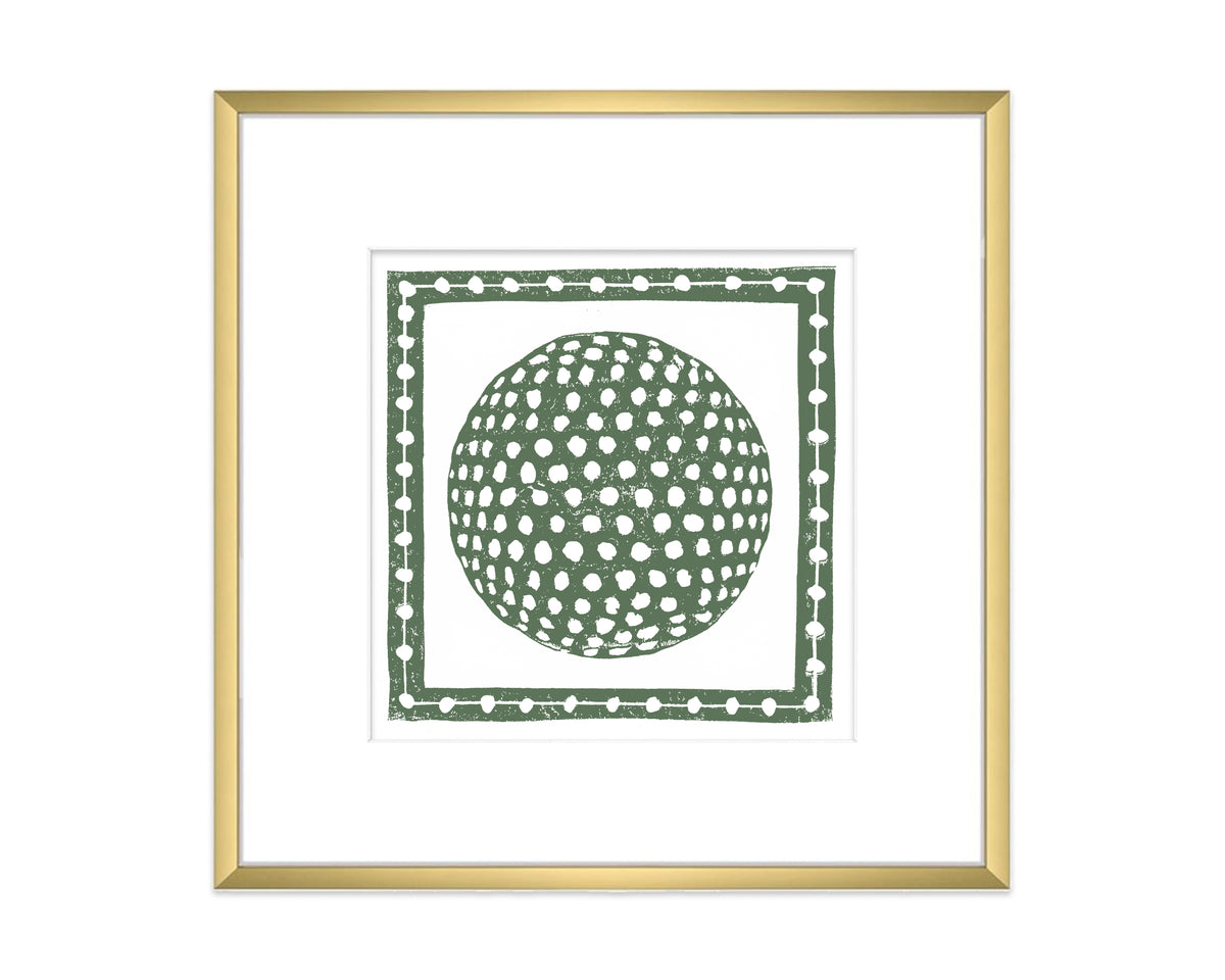 Framed artwork with a green golf ball inside a decorative border on a white background