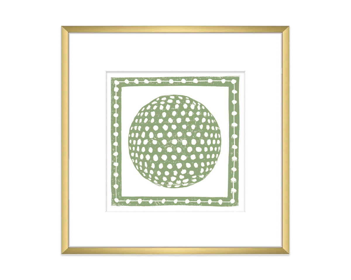 Framed artwork with a green golf ball inside a decorative border on a white background
