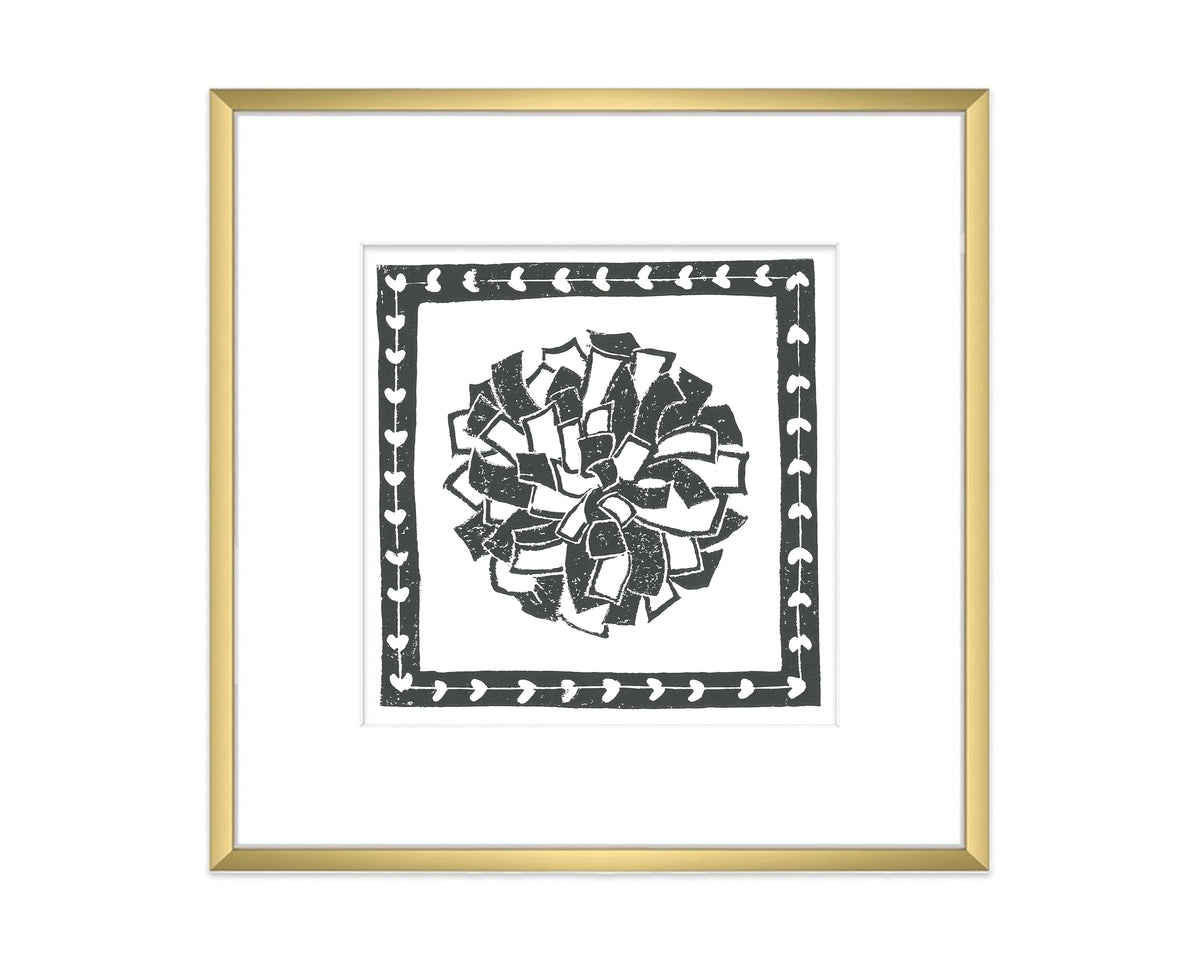 Framed artwork with a black and white pompon on a white background