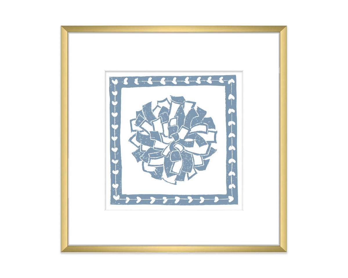Framed artwork with a blue and white pompon on a white background