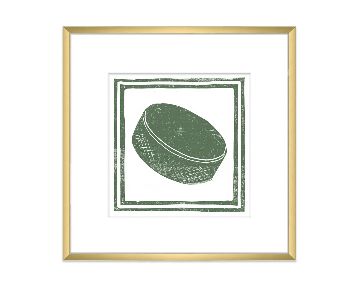 Framed artwork of a green hockey puck on a white background