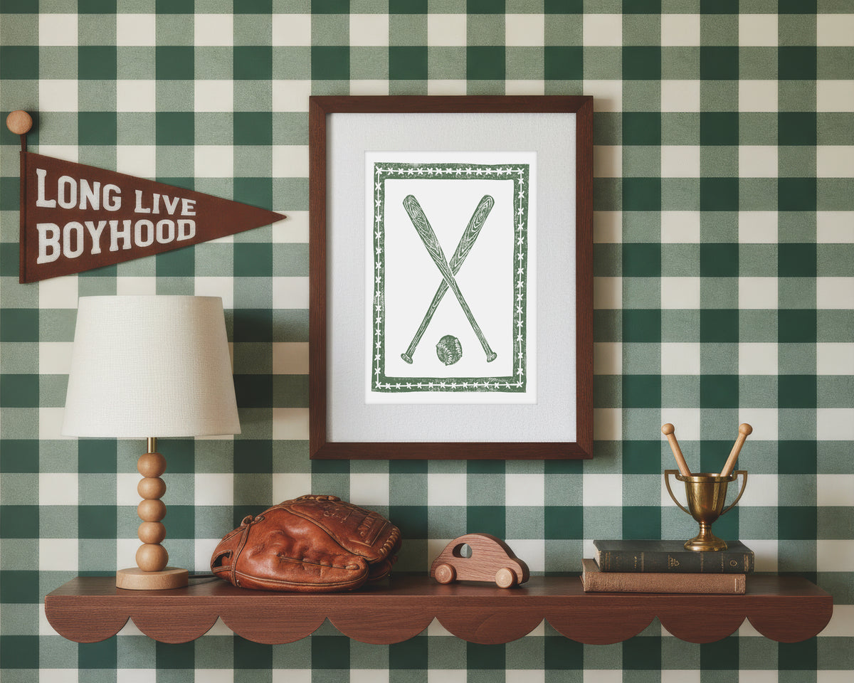 A framed art print of crossed green baseball bats and ball in a styled green and white bedroom