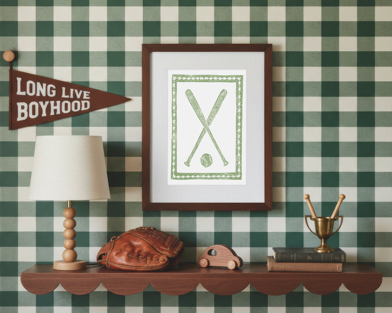 A framed art print of crossed green baseball bats and ball in a styled green and white bedroom