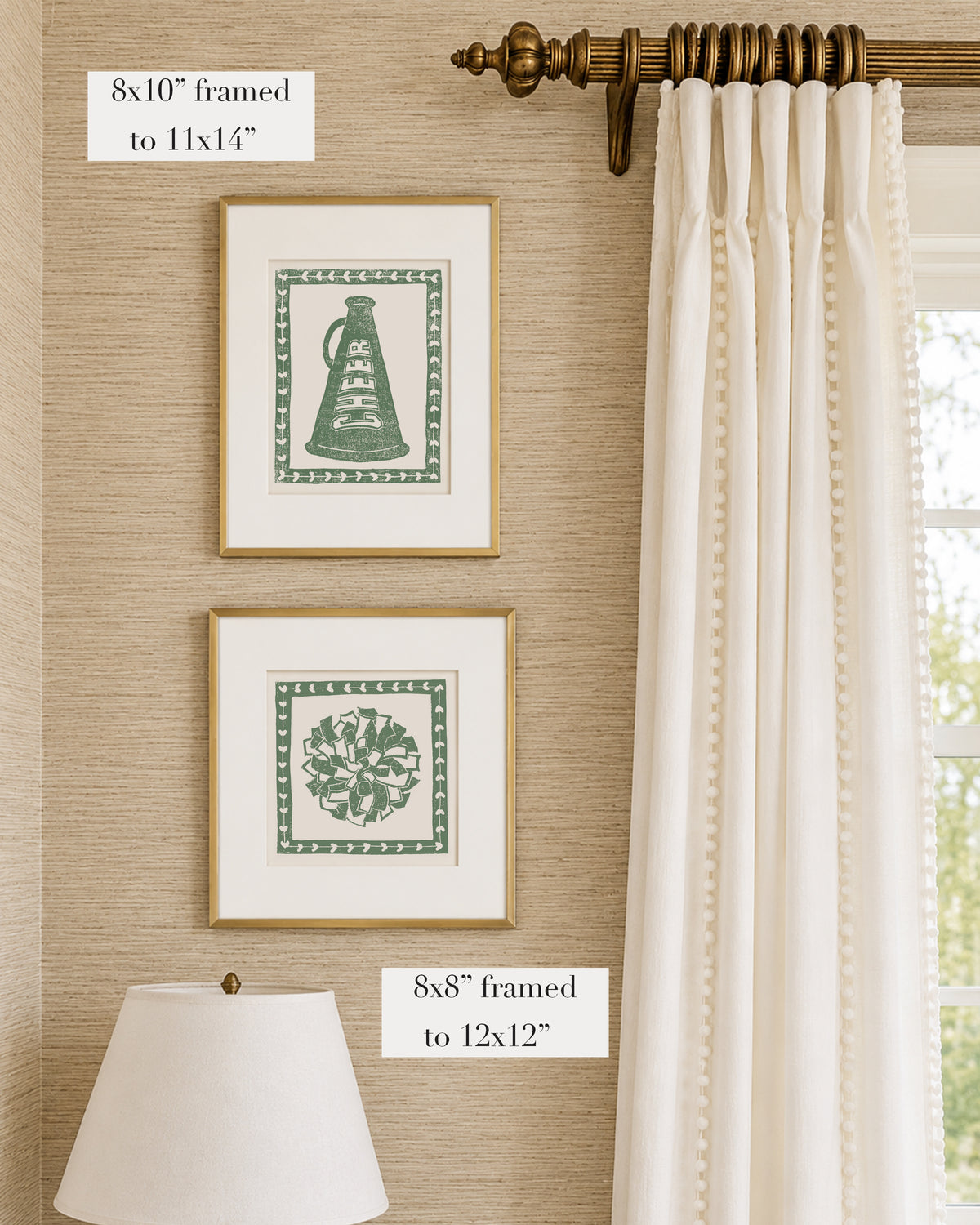 Framed grass green and white cheerleading themed artwork on a tan grasscloth wallpapered wall with a white window treatment and lampshade