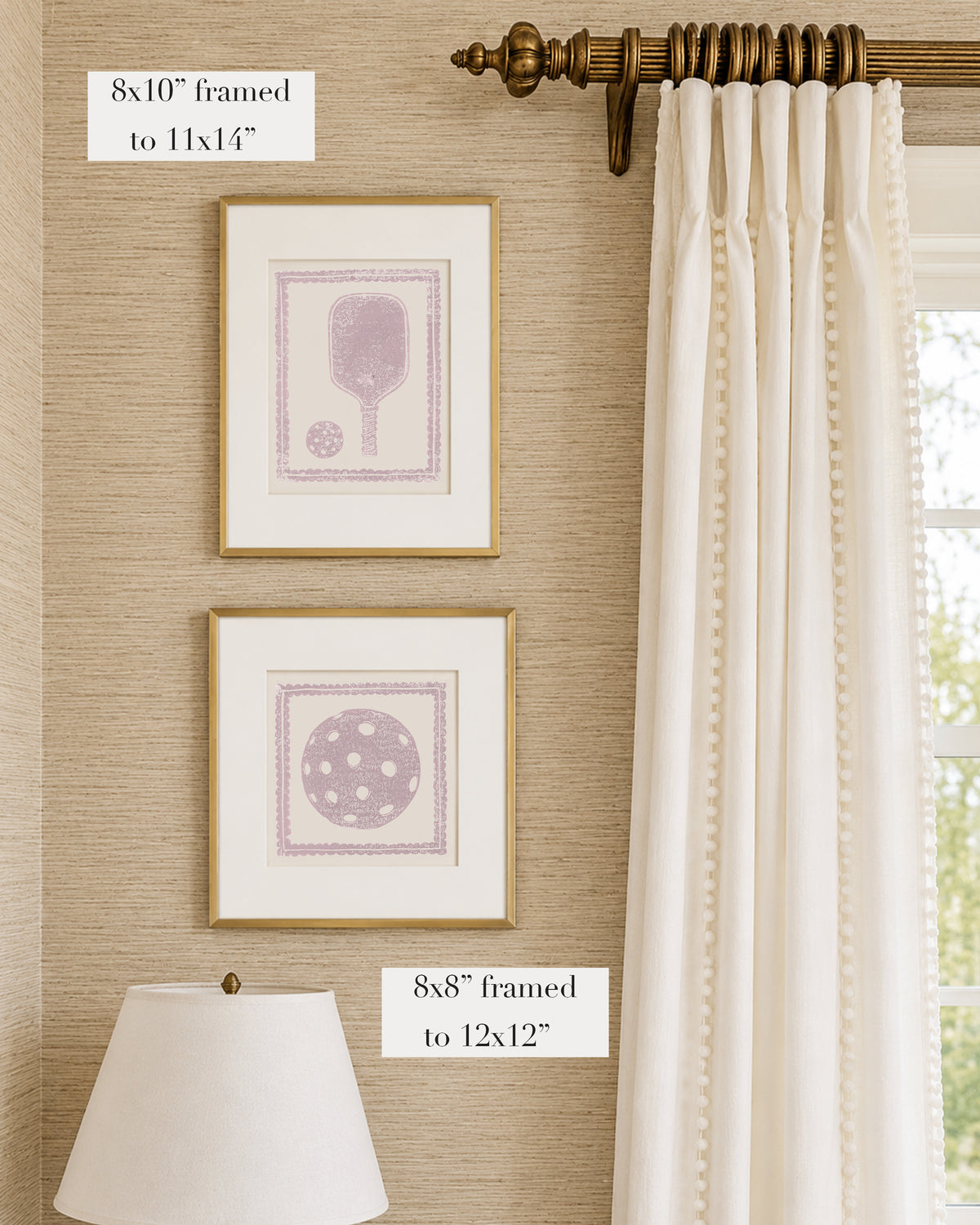 Framed mauve and white pickleball themed artwork on a tan grasscloth wallpapered wall with a white window treatment and lampshade