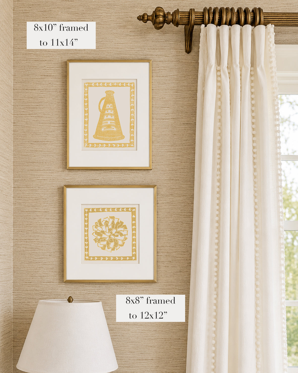 Framed mustard yellow and white cheerleading themed artwork on a tan grasscloth wallpapered wall with a white window treatment and lampshade
