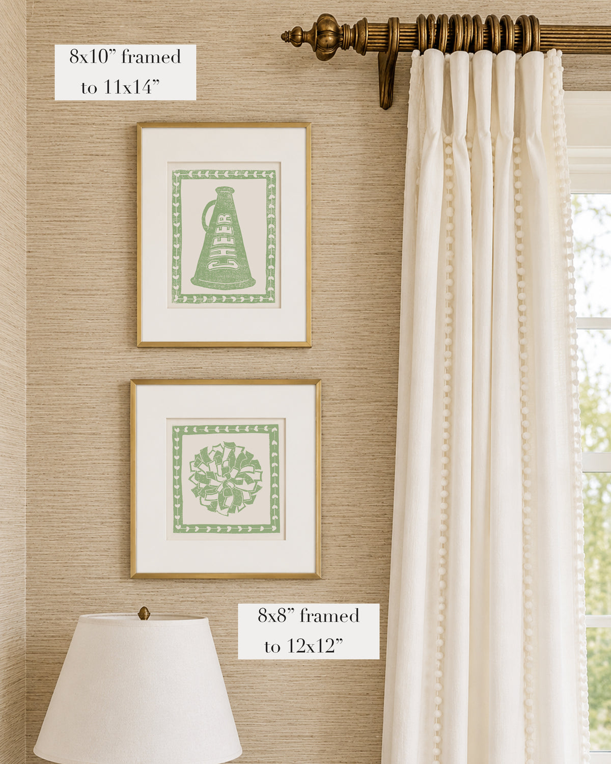 Framed sage green and white cheerleading themed artwork on a tan grasscloth wallpapered wall with a white window treatment and lampshade