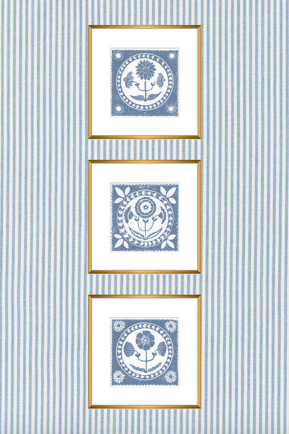 Three framed blue and white patterns on a striped blue and white wall.