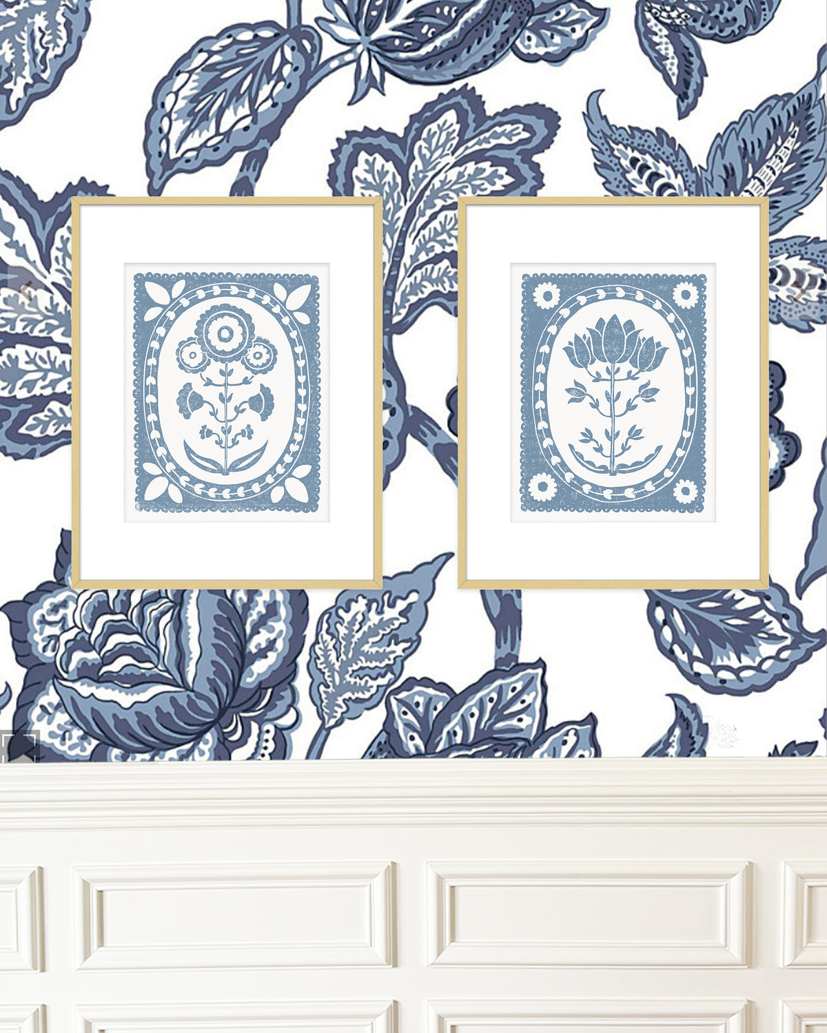 Two framed blue and white artworks on a decorative wall with floral patterns.