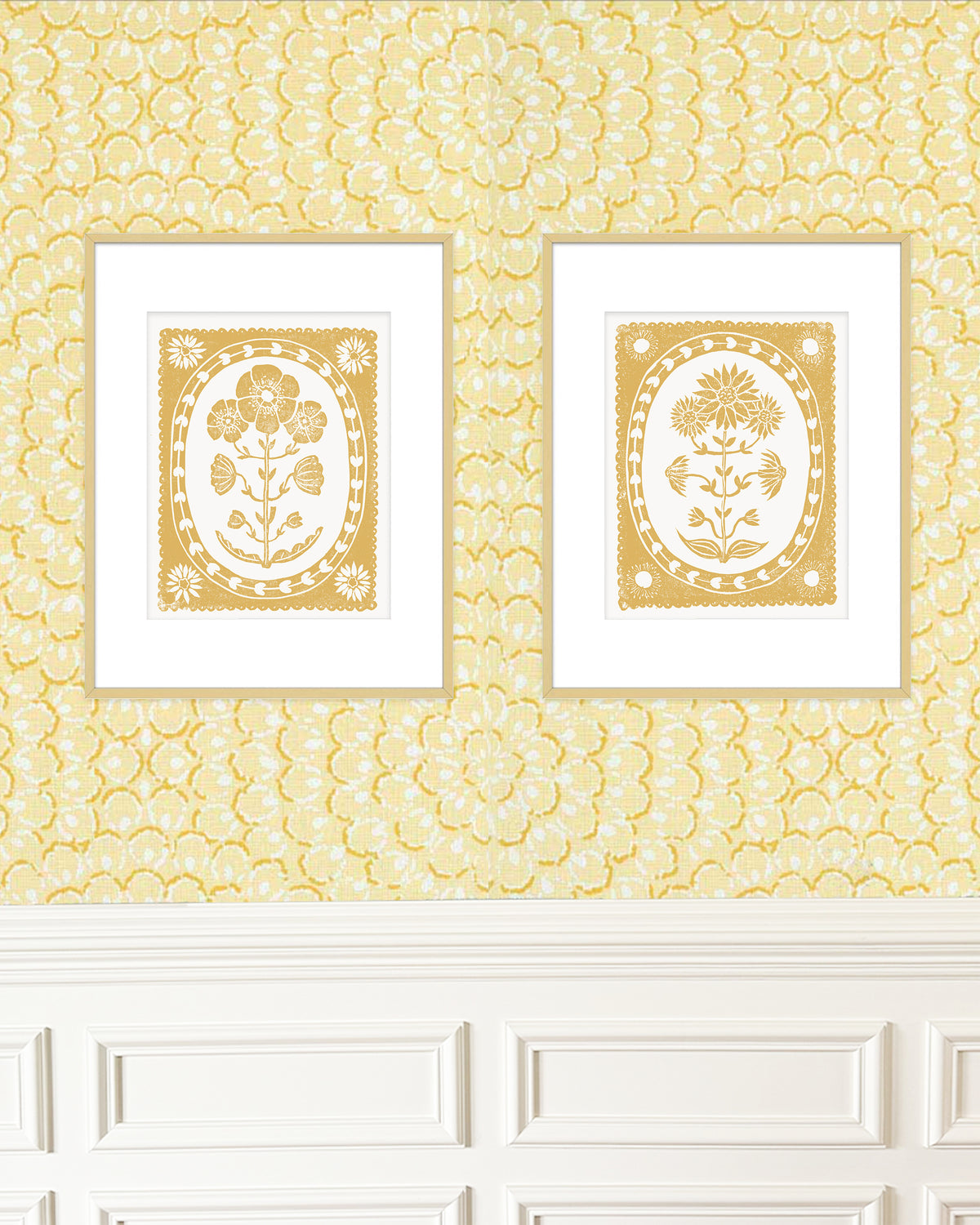 Two framed artworks with floral designs on a yellow patterned wall.