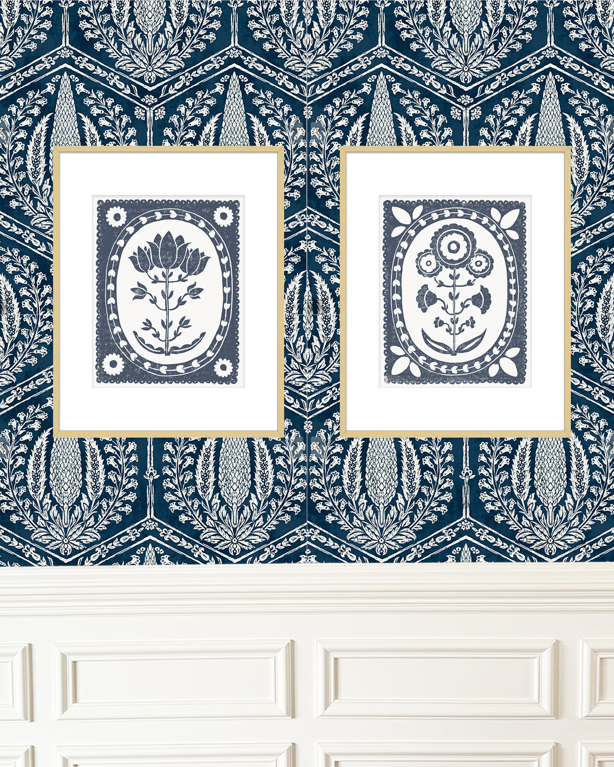 two navy blue and white botanical art prints framed on a patterned wallpaper wall
