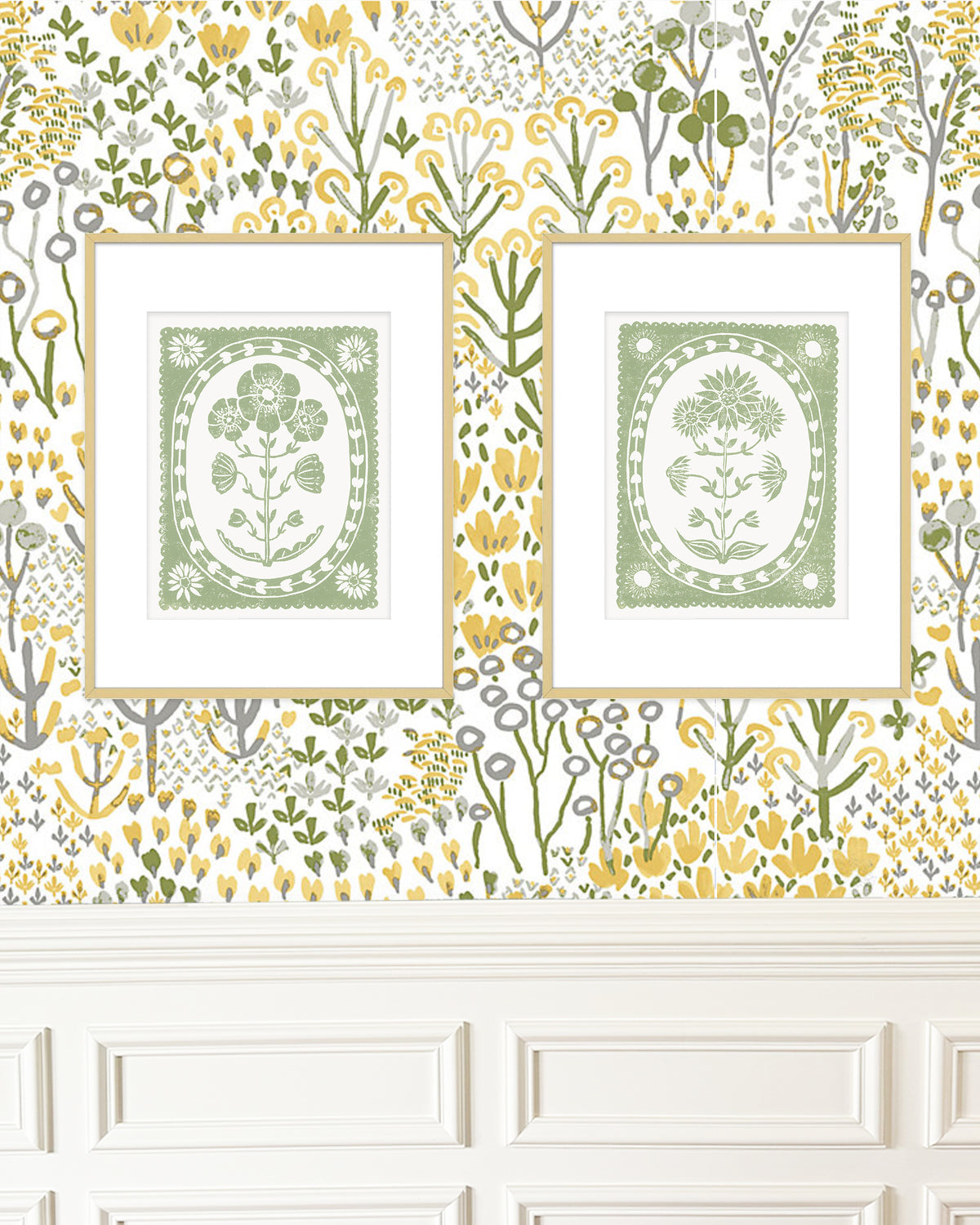 Two framed botanical prints on a decorative wall with floral border