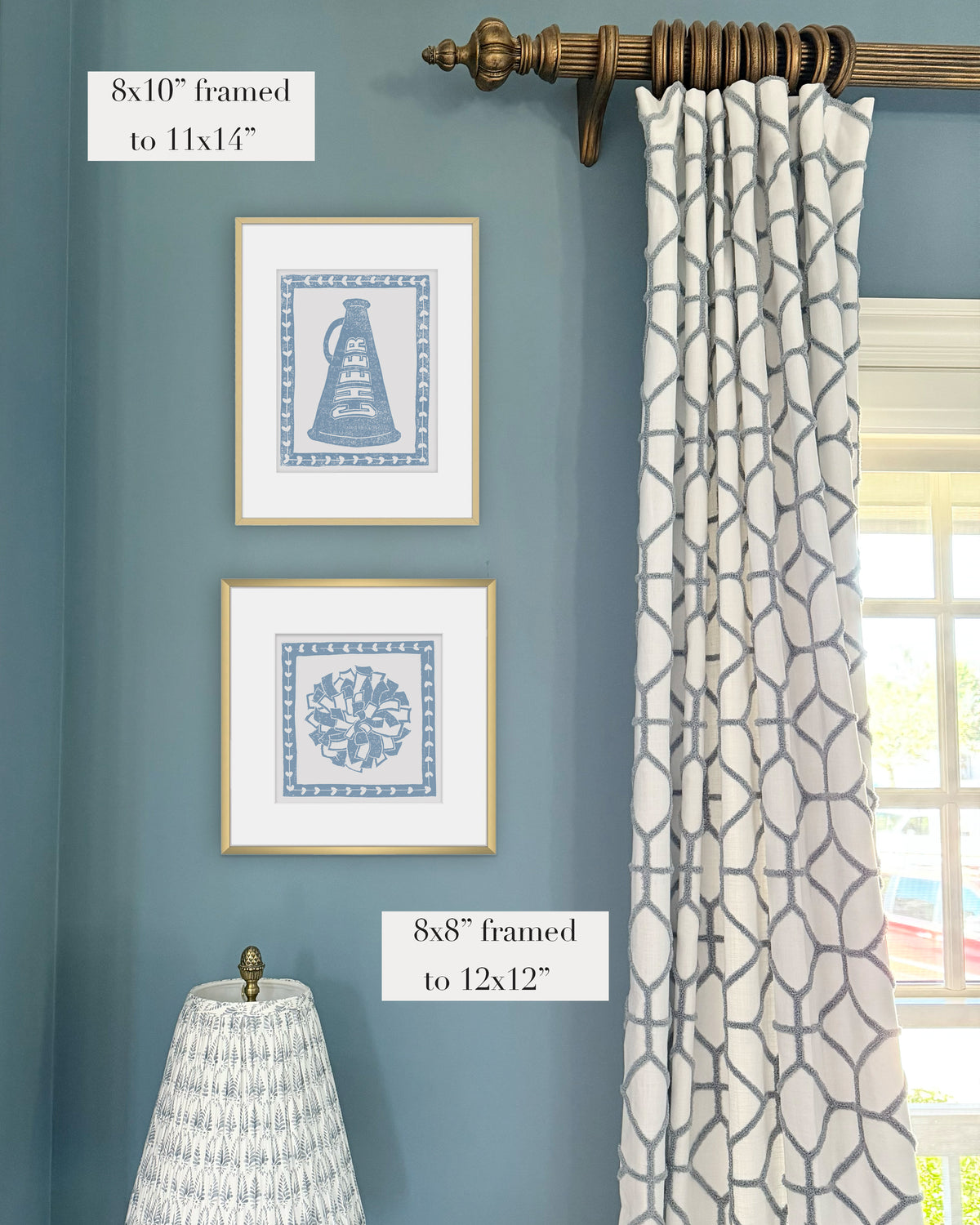 Framed cornflower blue cheerleading themed artwork on a blue wall with curtains and a lampshade.