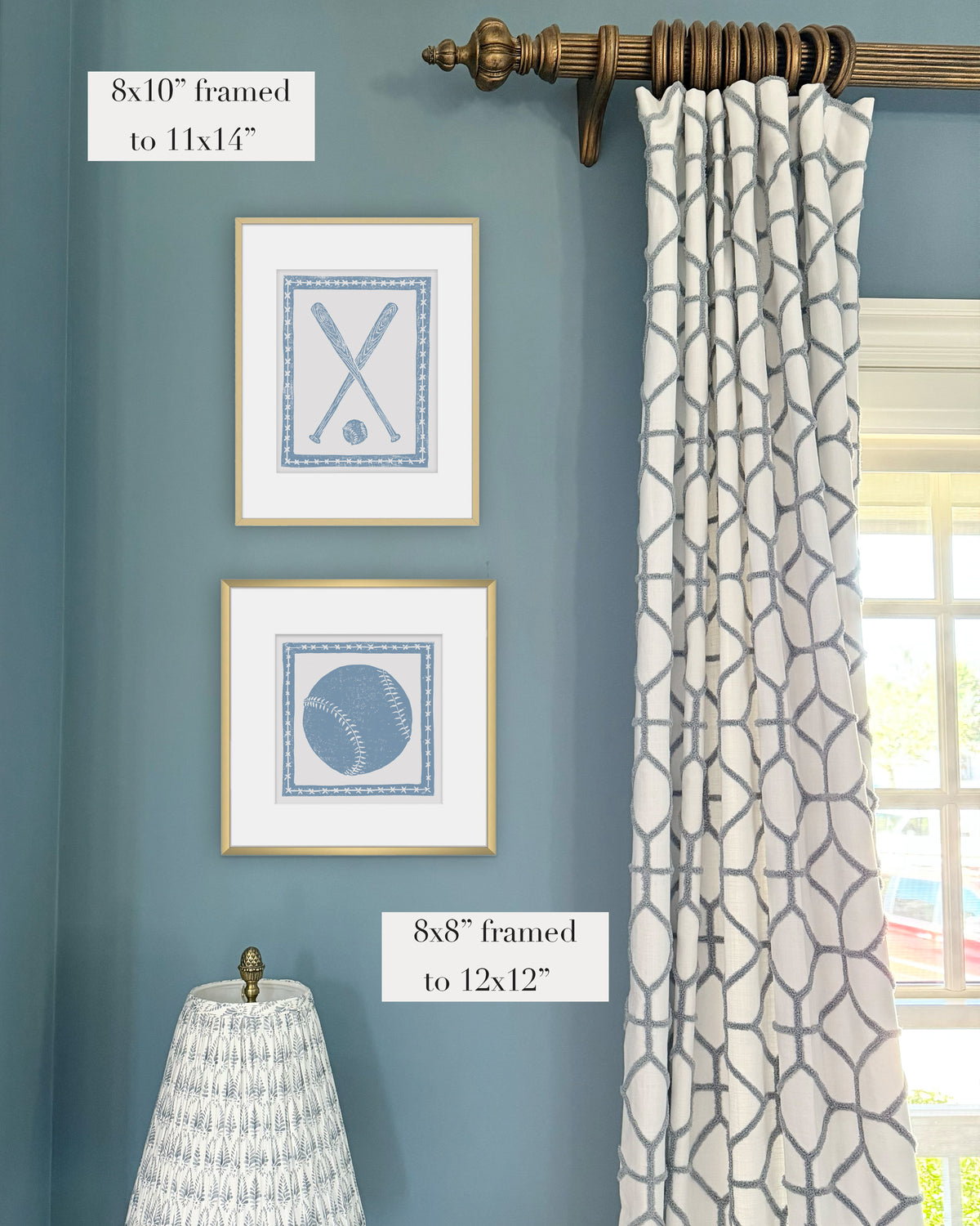 Framed light blue and white softball themed artwork on a blue grasscloth wallpapered wall with a white window treatment and lampshade