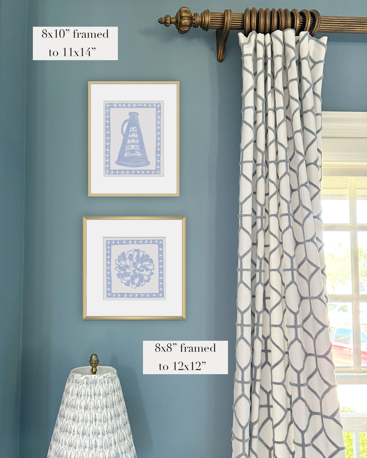 Framed hydrangea blue cheerleading themed artwork on a blue wall with curtains and a lampshade.