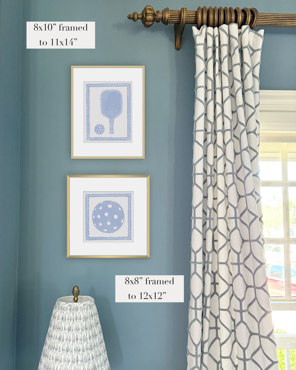 Framed hydrangea blue pickleball themed artwork on a blue wall with curtains and a lampshade.
