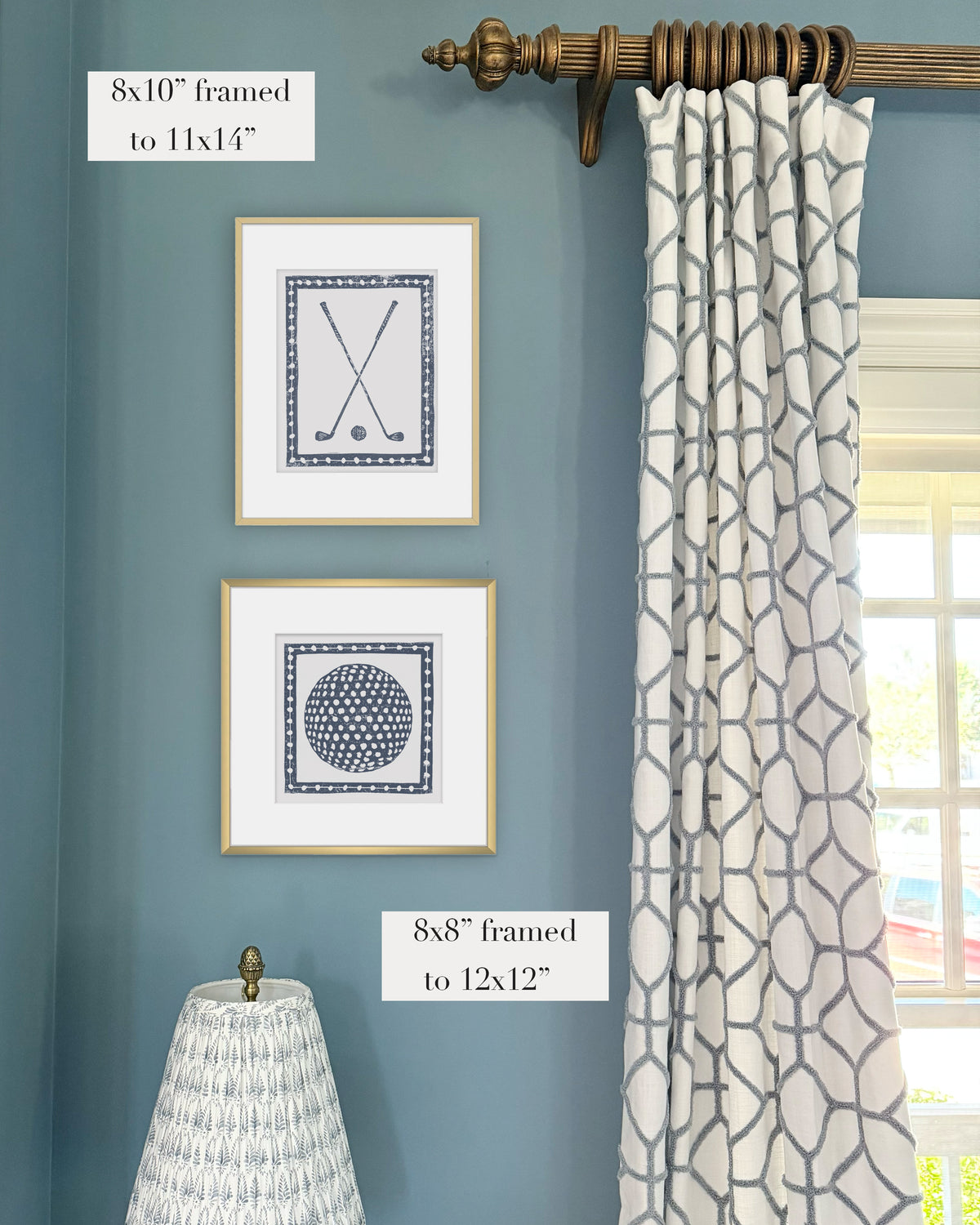 Framed navy blue golf themed artwork on a blue wall with curtains and a lampshade.