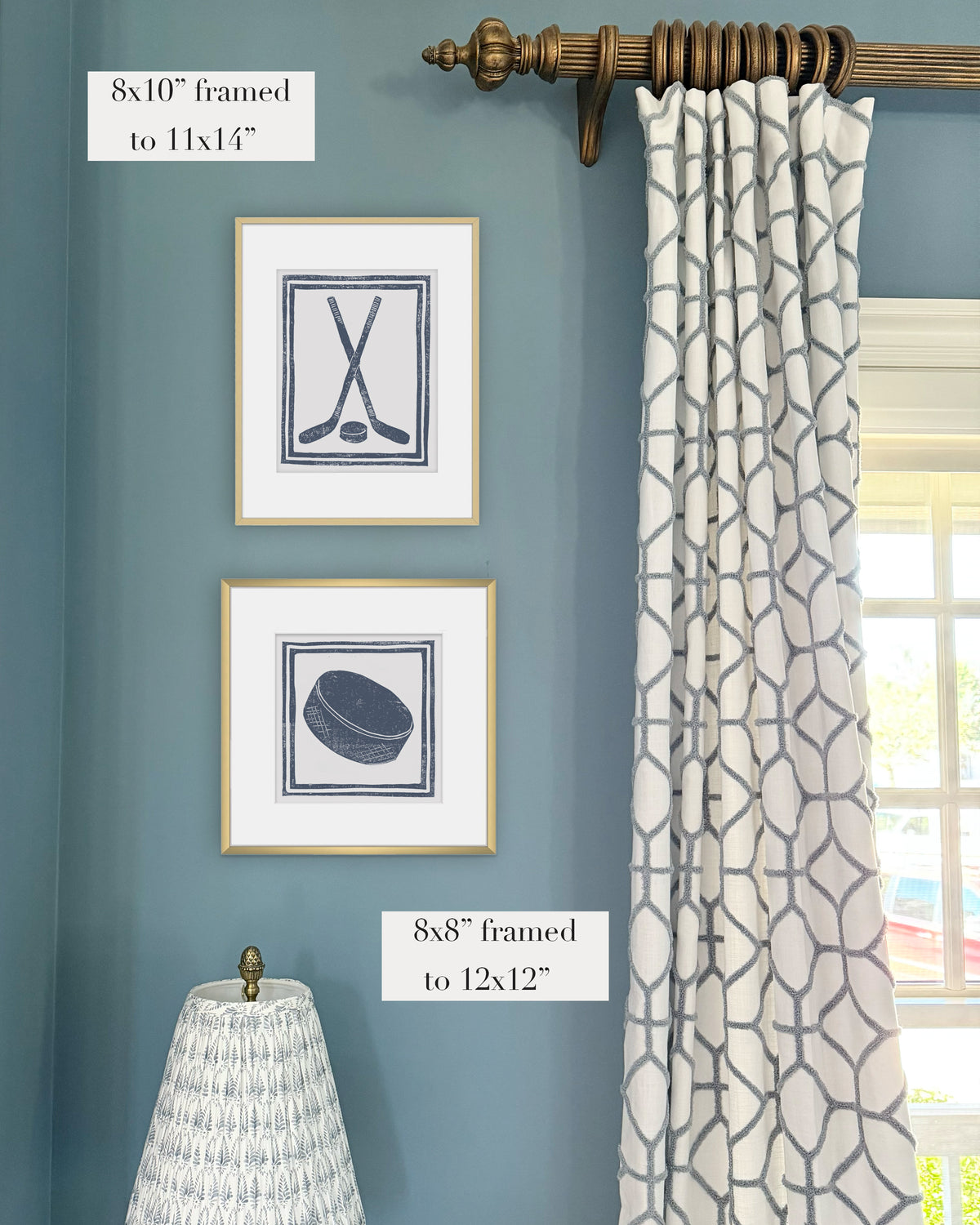 Framed navy blue hockey themed artwork on a blue wall with curtains and a lampshade.