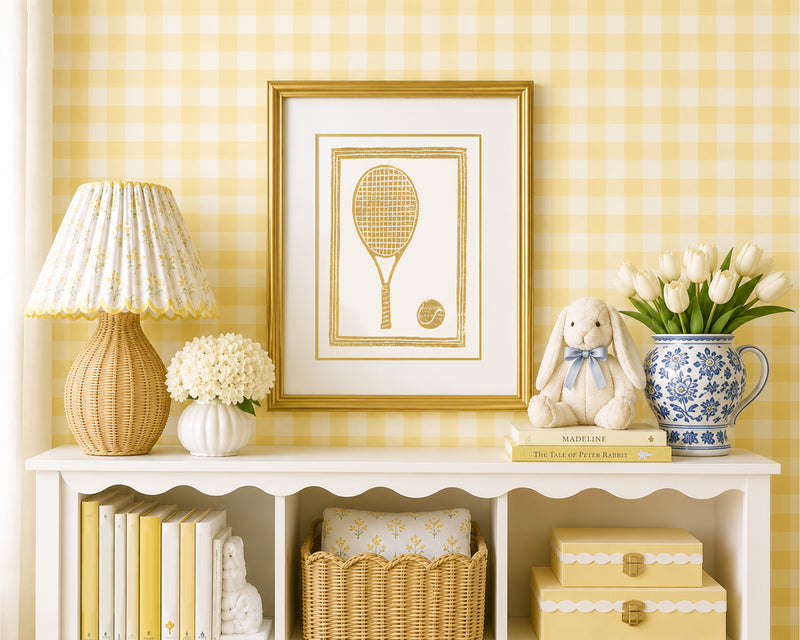 Framed mustard yellow tennis racket in a styled yellow and white bedroom
